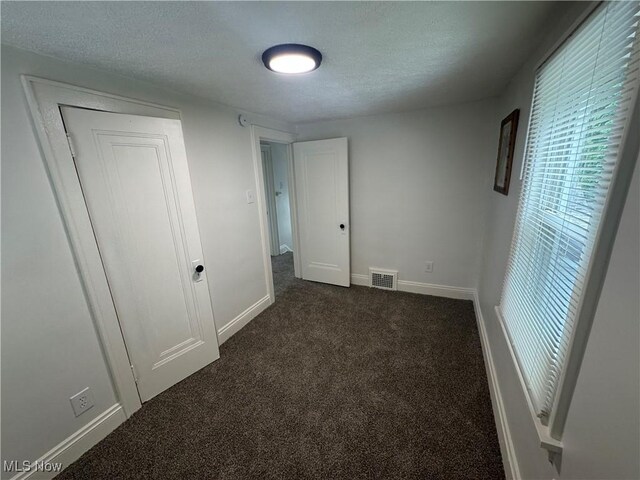 783 Jason Ave, Akron, OH 44314 - unfurnished bedroom with dark colored carpet and a textured ceiling