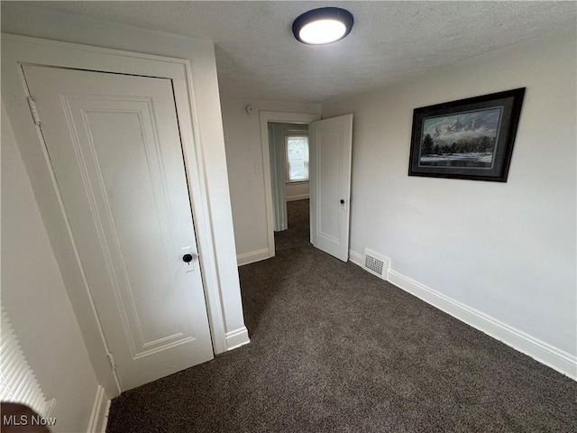 783 Jason Ave, Akron, OH 44314 - unfurnished bedroom with dark colored carpet and a textured ceiling