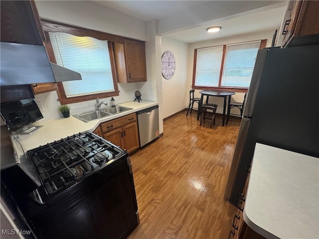 783 Jason Ave, Akron, OH 44314 - kitchen featuring stainless steel appliances, light wood-type flooring, light countertops, and range hood