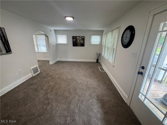 783 Jason Ave, Akron, OH 44314 - spare room featuring arched walkways, dark colored carpet, and healthy amount of natural light