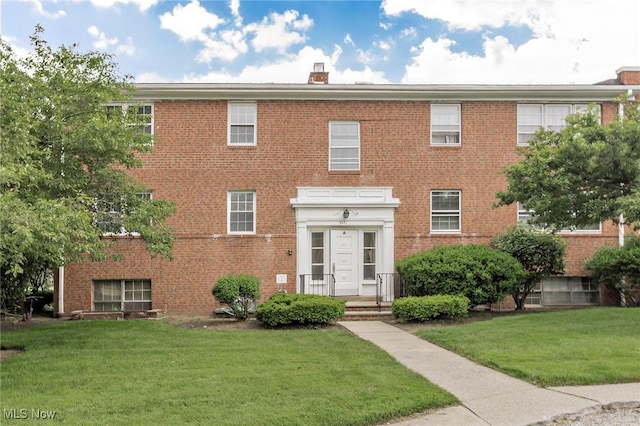 3271 Warrensville Center Rd Unit 4A, Shaker Heights, OH 44122 - view of front of house with brick siding, a front yard, and a chimney