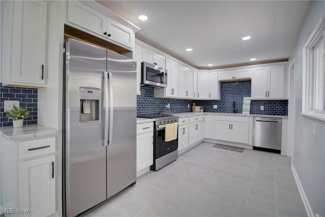 2764 Walter Rd, Westlake, OH 44145 - kitchen featuring appliances with stainless steel finishes, backsplash, white cabinetry, light tile patterned floors, and recessed lighting