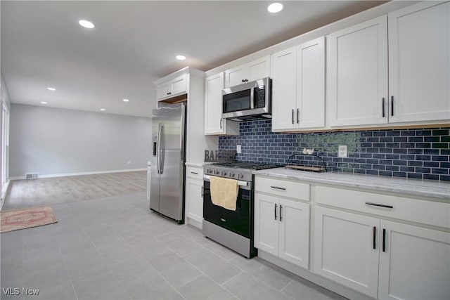 2764 Walter Rd, Westlake, OH 44145 - kitchen featuring stainless steel appliances, backsplash, white cabinetry, light stone countertops, and recessed lighting