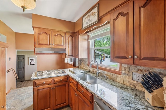 1455 Buckeye Cir, Salem, OH 44460 - kitchen featuring gas stovetop, under cabinet range hood, light stone counters, backsplash, and brown cabinetry