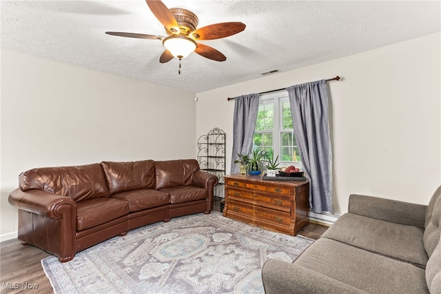 845 Dunny Ave, Sheffield Lake, OH 44054 - living area featuring wood finished floors, ceiling fan, a textured ceiling, and a baseboard heating unit