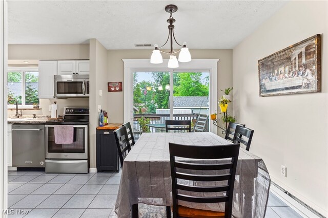 845 Dunny Ave, Sheffield Lake, OH 44054 - dining room featuring light tile patterned flooring, a textured ceiling, and baseboard heating