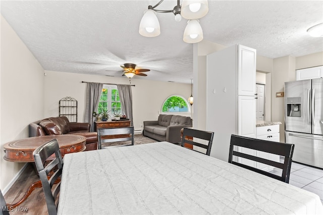 845 Dunny Ave, Sheffield Lake, OH 44054 - dining room featuring a textured ceiling, a ceiling fan, and a baseboard heating unit