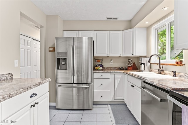 845 Dunny Ave, Sheffield Lake, OH 44054 - kitchen featuring appliances with stainless steel finishes, white cabinets, light tile patterned flooring, recessed lighting, and light stone countertops
