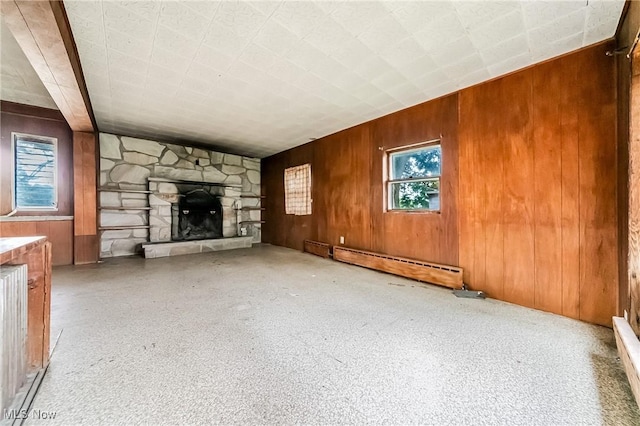 9509 Reed Rd, Columbia Station, OH 44028 - unfurnished living room featuring wooden walls, a baseboard radiator, and a stone fireplace