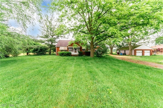 9509 Reed Rd, Columbia Station, OH 44028 - view of green lawn with driveway and a garage