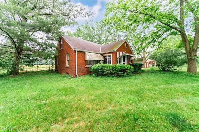 9509 Reed Rd, Columbia Station, OH 44028 - view of side of home featuring brick siding and a lawn