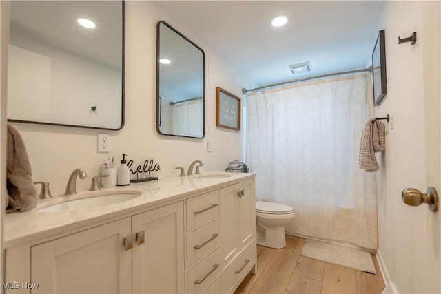 7080 Wren Ave NW, North Canton, OH 44720 - full bathroom featuring wood finished floors, double vanity, a shower with shower curtain, and recessed lighting