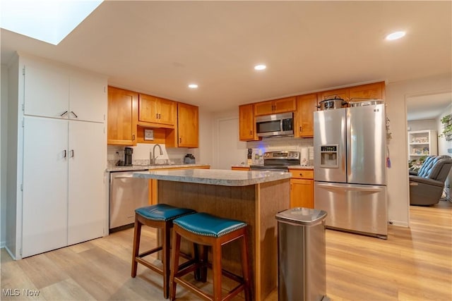 7080 Wren Ave NW, North Canton, OH 44720 - kitchen featuring stainless steel appliances, light wood-style floors, a kitchen island, recessed lighting, and light countertops