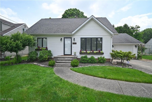 7673 N Lima Rd, Poland, OH 44514 - view of front of house with a shingled roof, a front yard, a garage, and asphalt driveway