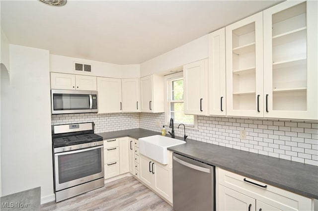 7673 N Lima Rd, Poland, OH 44514 - kitchen with stainless steel appliances, dark countertops, light wood-type flooring, and tasteful backsplash