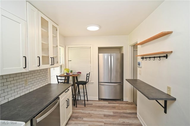 7673 N Lima Rd, Poland, OH 44514 - kitchen featuring stainless steel appliances, dark countertops, light wood finished floors, tasteful backsplash, and open shelves