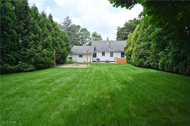 7673 N Lima Rd, Poland, OH 44514 - rear view of house with a patio area, a yard, and a chimney