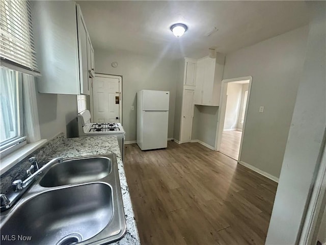 3180 W 90th St, Cleveland, OH 44102 - kitchen featuring white appliances, wood finished floors, light stone countertops, and white cabinets