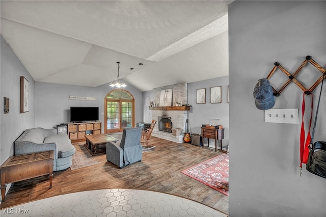 5065 Broadway, Lorain, OH 44052 - living area featuring lofted ceiling, wood finished floors, a fireplace, and a textured ceiling