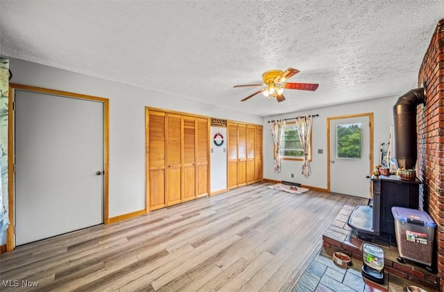 1518 State Route 46 N, Jefferson, OH 44047 - foyer entrance with a wood stove, ceiling fan, light wood finished floors, and a textured ceiling