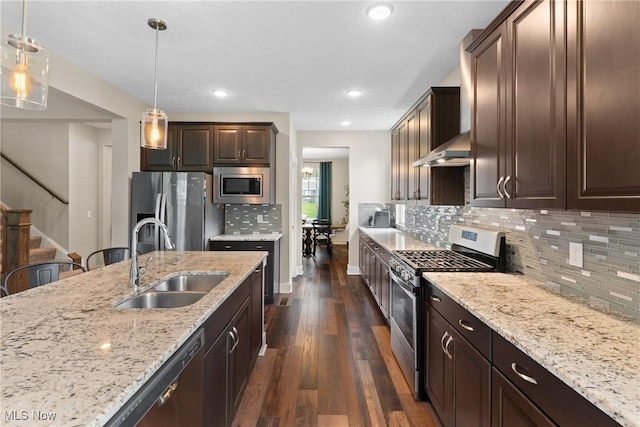 7733 Timber Ave, Hudson, OH 44236 - kitchen with appliances with stainless steel finishes, wall chimney range hood, dark wood-style floors, dark brown cabinets, and light stone countertops