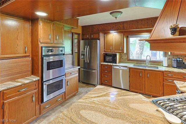 2307 Deerpath Dr, Sandusky, OH 44870 - kitchen with appliances with stainless steel finishes, brown cabinets, and decorative backsplash