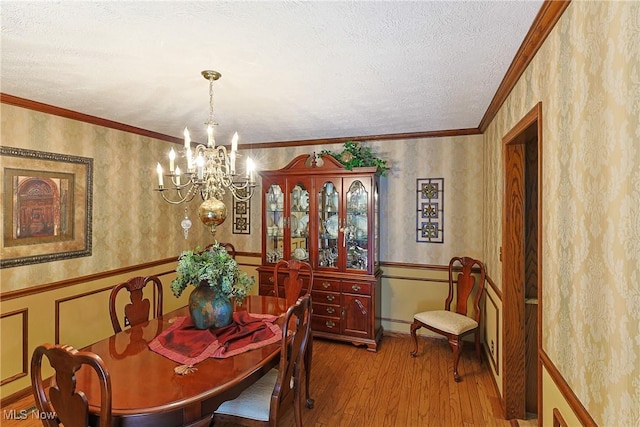 2307 Deerpath Dr, Sandusky, OH 44870 - dining room with a chandelier, hardwood / wood-style floors, wallpapered walls, wainscoting, and a textured ceiling