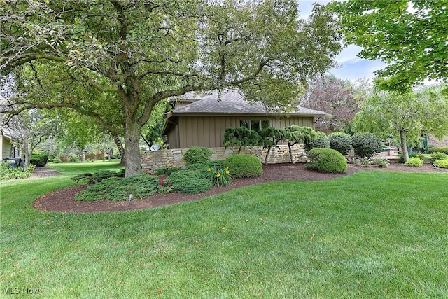 2307 Deerpath Dr, Sandusky, OH 44870 - view of home's exterior with board and batten siding, a lawn, stone siding, and a shingled roof