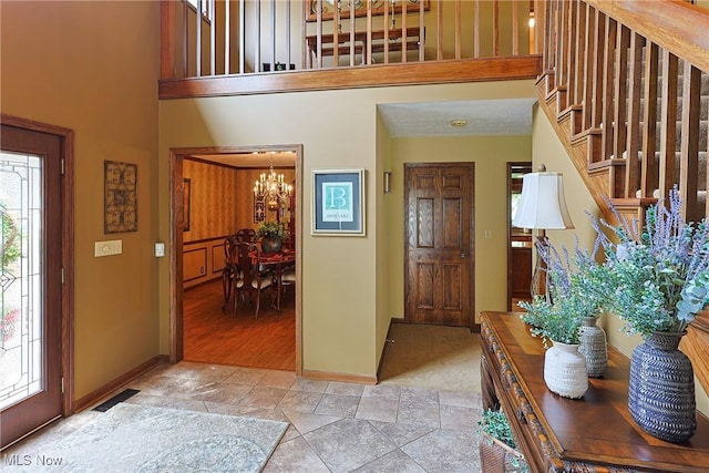 2307 Deerpath Dr, Sandusky, OH 44870 - entrance foyer with a chandelier, stairway, light stone finish floors, and a towering ceiling