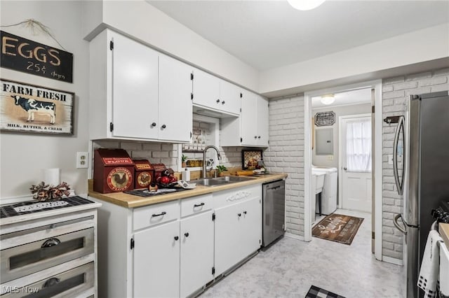 30221 Harrison St, Willowick, OH 44095 - kitchen with appliances with stainless steel finishes, white cabinets, light countertops, tasteful backsplash, and washer / clothes dryer