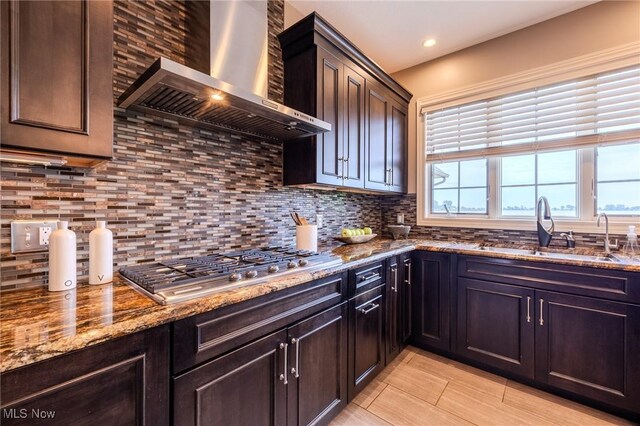 854 Crosstree Ln, Sandusky, OH 44870 - kitchen featuring wall chimney exhaust hood, stainless steel gas stovetop, decorative backsplash, stone counters, and dark brown cabinetry