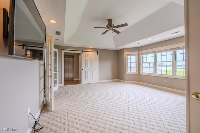 854 Crosstree Ln, Sandusky, OH 44870 - carpeted spare room featuring ceiling fan, recessed lighting, a tray ceiling, and a barn door