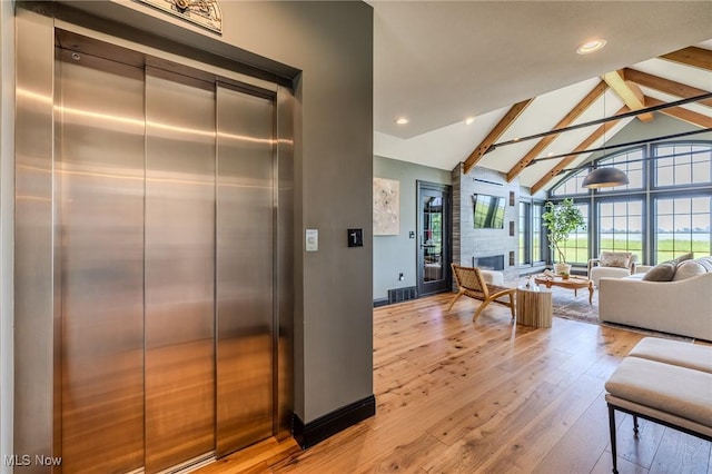 854 Crosstree Ln, Sandusky, OH 44870 - living area with elevator, beamed ceiling, high vaulted ceiling, light wood-style flooring, and a fireplace