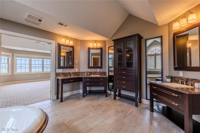 854 Crosstree Ln, Sandusky, OH 44870 - bathroom featuring vaulted ceiling, two vanities, and a bath