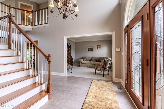 854 Crosstree Ln, Sandusky, OH 44870 - foyer featuring a towering ceiling, stairs, a chandelier, and ornamental molding