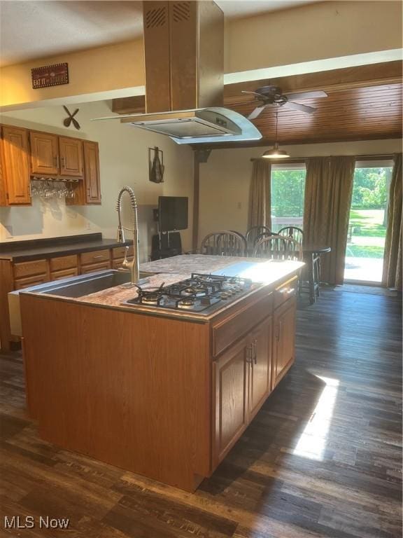 3290 NW Sweitzer St NW, Uniontown, OH 44685 - kitchen with stainless steel gas stovetop, dark wood-style floors, a ceiling fan, and brown cabinetry