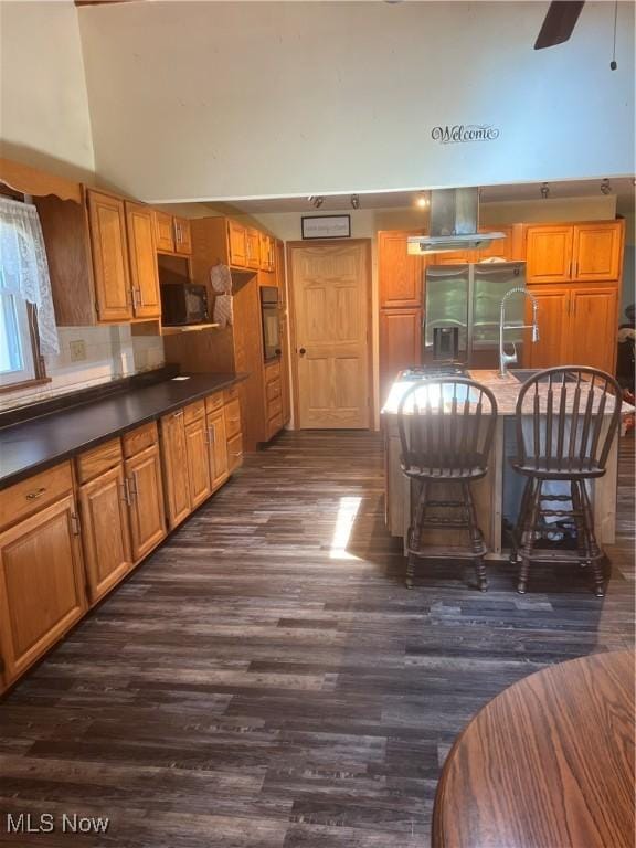 3290 NW Sweitzer St NW, Uniontown, OH 44685 - kitchen featuring black appliances, dark wood-style flooring, dark countertops, a ceiling fan, and brown cabinetry