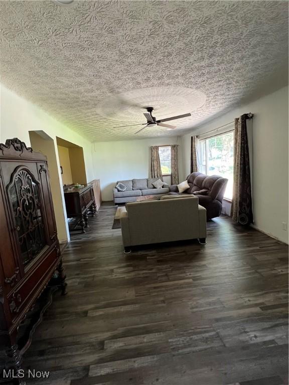 3290 NW Sweitzer St NW, Uniontown, OH 44685 - living area featuring dark wood-type flooring, a textured ceiling, and a ceiling fan