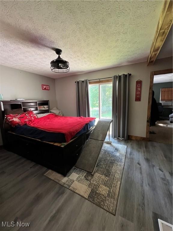 3290 NW Sweitzer St NW, Uniontown, OH 44685 - bedroom featuring wood finished floors, a textured ceiling, and access to exterior