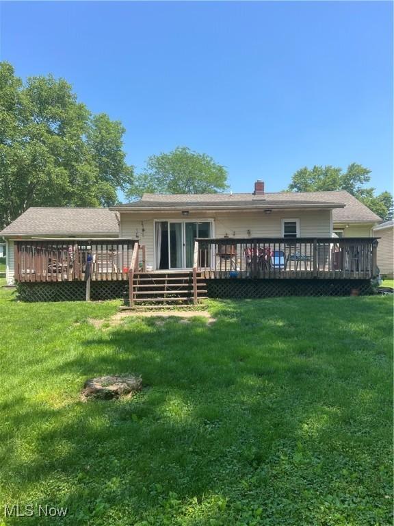 3290 NW Sweitzer St NW, Uniontown, OH 44685 - rear view of property with a deck and a yard