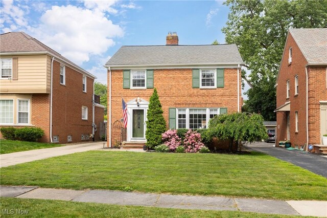 3678 Lynnfield Rd, Shaker Heights, OH 44122 - colonial-style house featuring a chimney, a front lawn, brick siding, and driveway