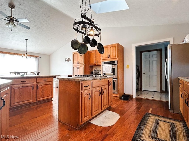 3585 Hayfield Rd, Dresden, OH 43821 - kitchen with appliances with stainless steel finishes, vaulted ceiling, dark wood-type flooring, a skylight, and a center island