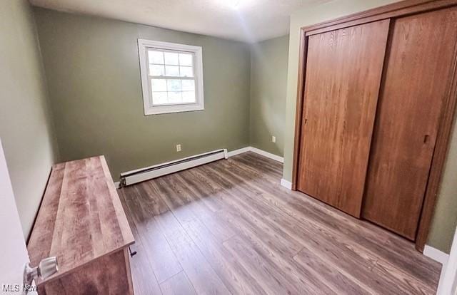 503 W Pidgeon Rd, Salem, OH 44460 - unfurnished bedroom with a baseboard radiator, a closet, and wood finished floors