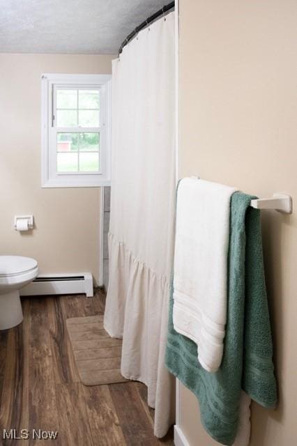 503 W Pidgeon Rd, Salem, OH 44460 - full bath with a baseboard heating unit, wood finished floors, a textured ceiling, and a shower with curtain