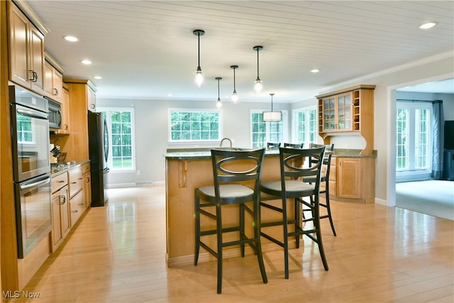 2878 Beaver Trl, Cortland, OH 44410 - kitchen featuring appliances with stainless steel finishes, recessed lighting, light wood-type flooring, a center island with sink, and a breakfast bar