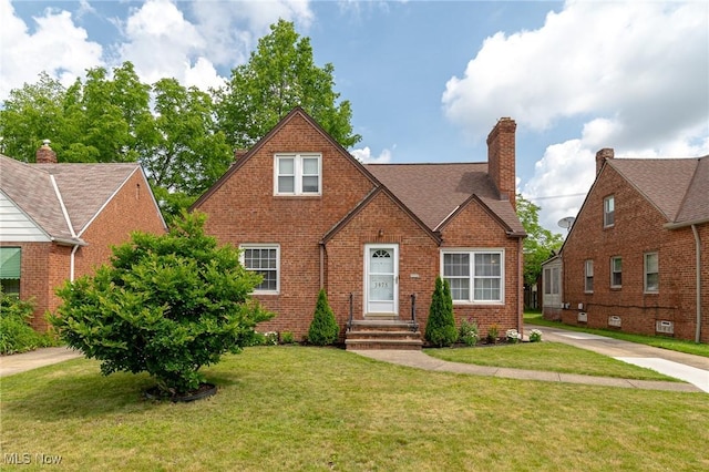 3975 Eastway Rd, South Euclid, OH 44118 - tudor house with brick siding, a front lawn, and a chimney