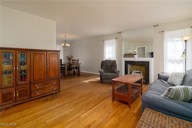 3975 Eastway Rd, South Euclid, OH 44118 - living area featuring light wood-style floors, a chandelier, and a fireplace with flush hearth