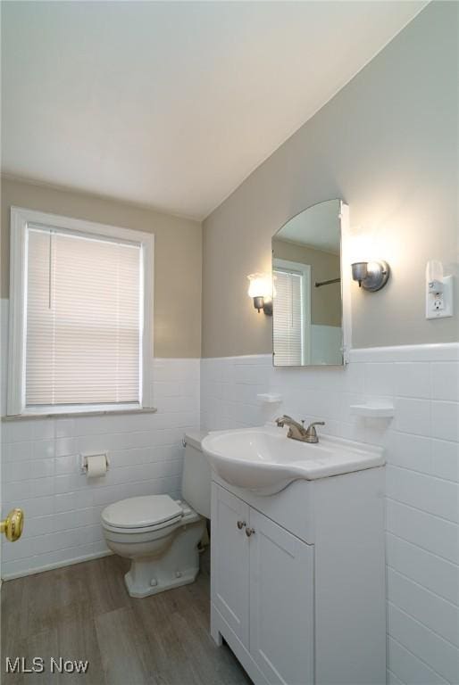 3975 Eastway Rd, South Euclid, OH 44118 - bathroom featuring tile walls, wood finished floors, vanity, and a wainscoted wall