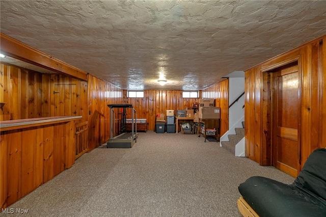 3975 Eastway Rd, South Euclid, OH 44118 - living area with wooden walls, carpet, a textured ceiling, and stairway