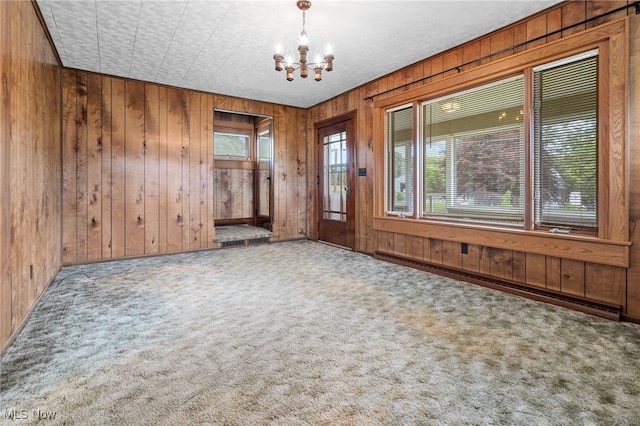 11861 Moffitt St SW, Massillon, OH 44647 - carpeted empty room featuring a chandelier, wooden walls, and baseboard heating